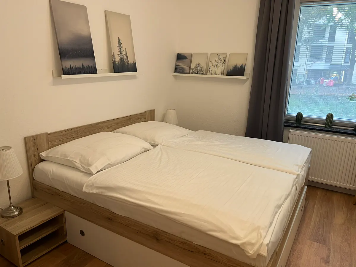 Schlafzimmer mit Doppelbett und Bildern über dem Bett